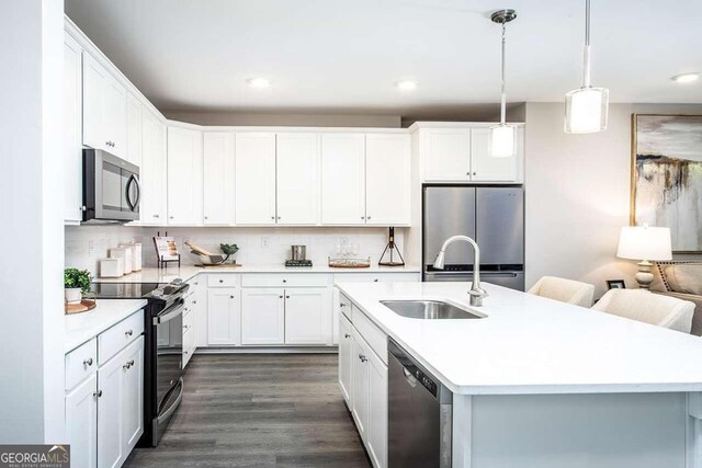 kitchen with stainless steel appliances, white cabinets, decorative backsplash, sink, and dark wood-type flooring