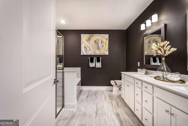 full bath with double vanity, baseboards, toilet, a sink, and a bath