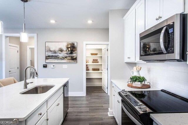 kitchen featuring backsplash, dark hardwood / wood-style flooring, stainless steel appliances, pendant lighting, and sink