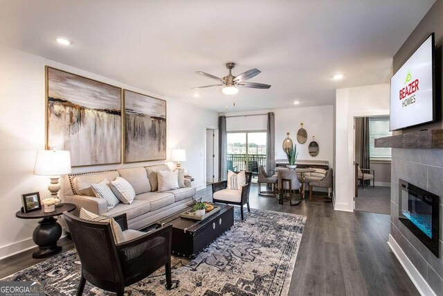 living room featuring dark wood-type flooring, a tile fireplace, and ceiling fan