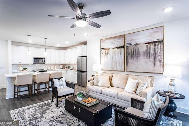 living room featuring sink, ceiling fan, and dark hardwood / wood-style floors