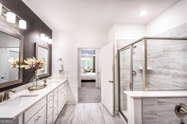 bathroom featuring dual vanity, ceiling fan, and an enclosed shower