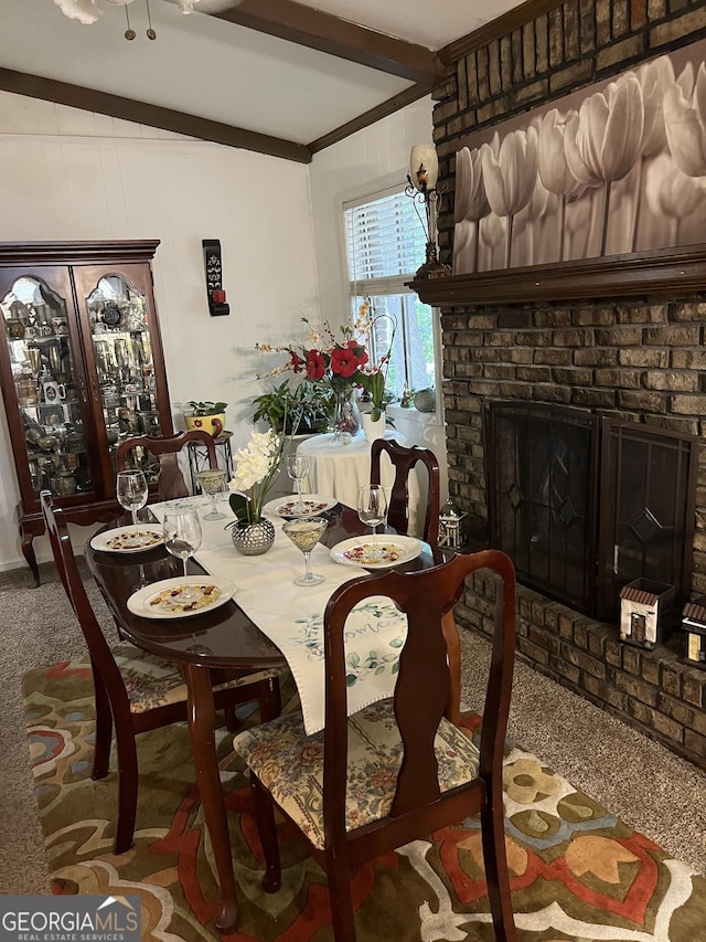 dining room featuring beamed ceiling, a fireplace, and carpet flooring