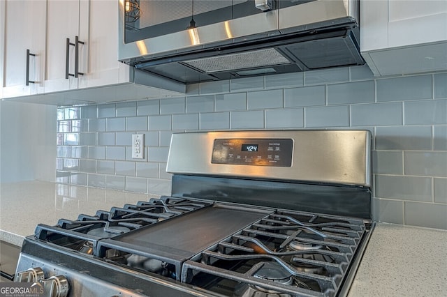 details featuring white cabinetry, decorative backsplash, light stone counters, and stainless steel appliances