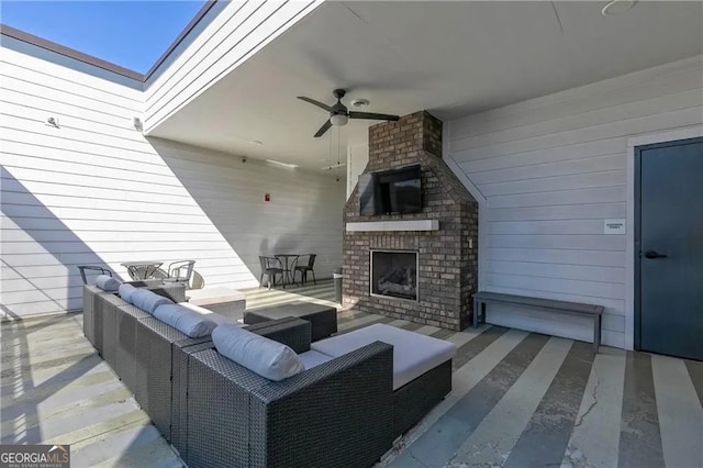 view of patio / terrace with an outdoor living space with a fireplace and ceiling fan