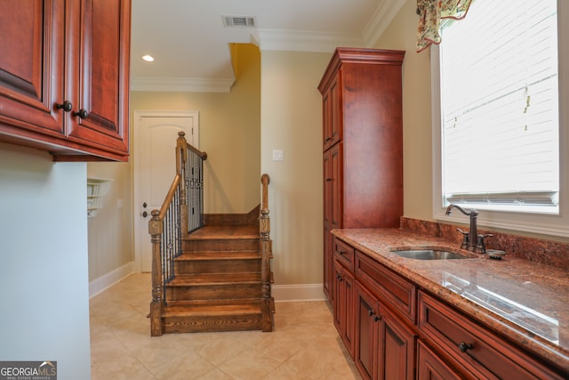 interior space with ornamental molding, sink, and light tile patterned flooring