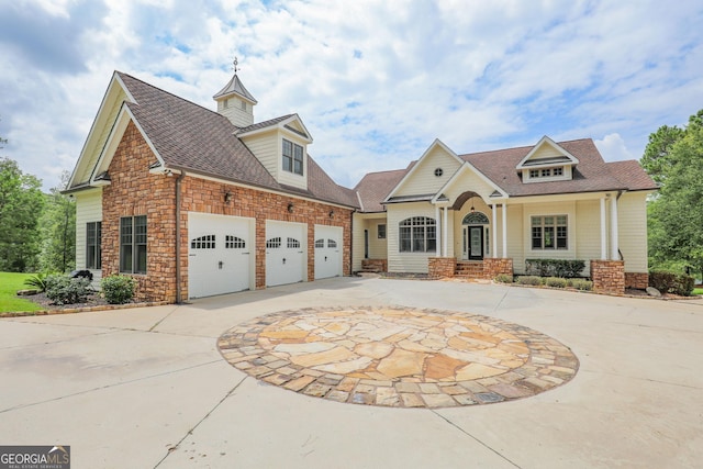 view of front of house with a garage, stone siding, a shingled roof, and curved driveway