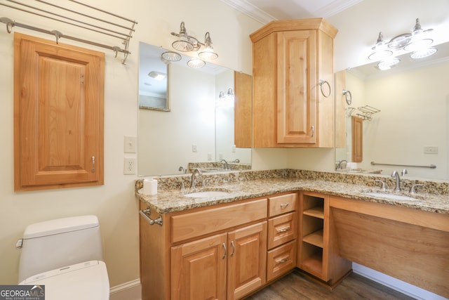 bathroom with double vanity, wood-type flooring, crown molding, and toilet