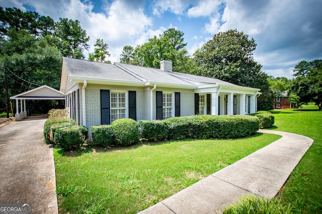 view of front of home with a carport and a front lawn