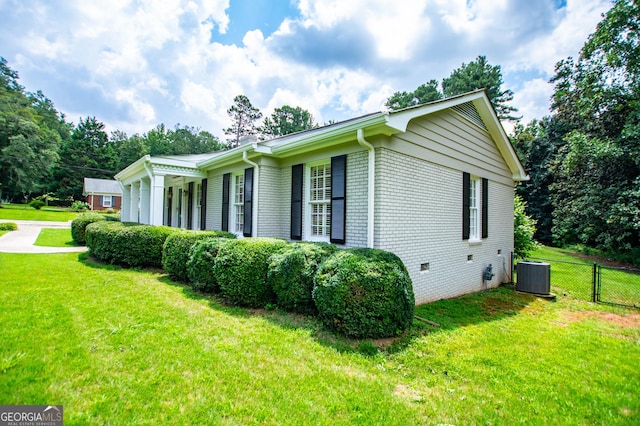 view of property exterior with central AC and a yard