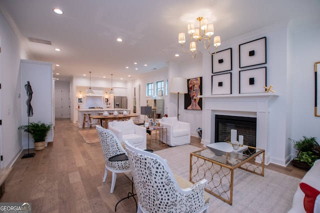 living room featuring a notable chandelier and light hardwood / wood-style floors