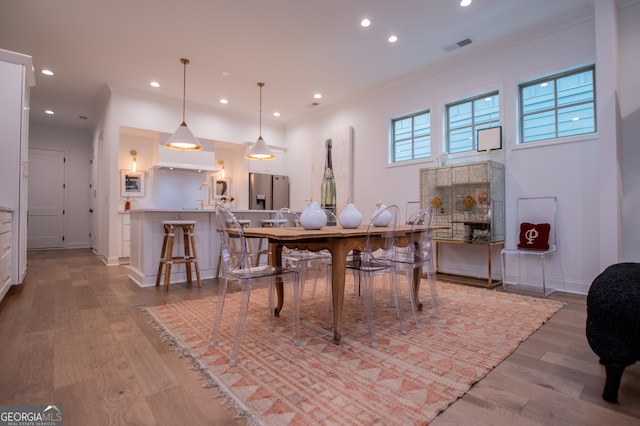 dining area featuring hardwood / wood-style flooring and ornamental molding