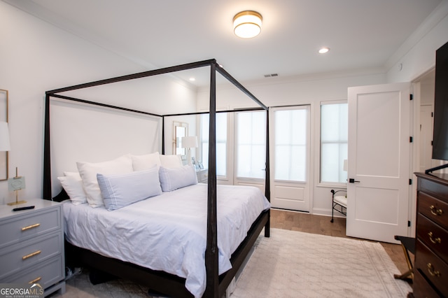 bedroom with light wood-type flooring and ornamental molding