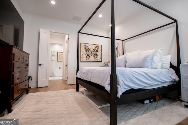 bedroom with ensuite bath, light hardwood / wood-style flooring, and ornamental molding