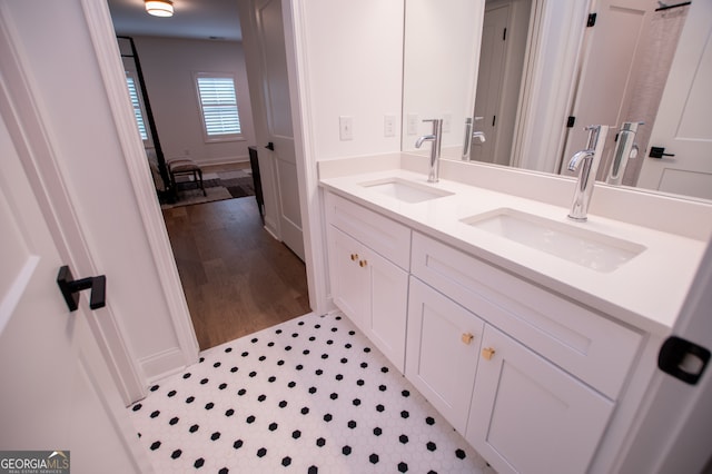 bathroom with hardwood / wood-style flooring and dual vanity