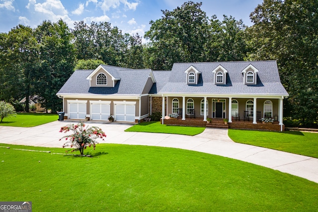 new england style home featuring covered porch, a garage, and a front lawn