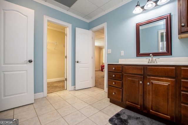 bathroom with vanity, crown molding, a paneled ceiling, and tile patterned floors