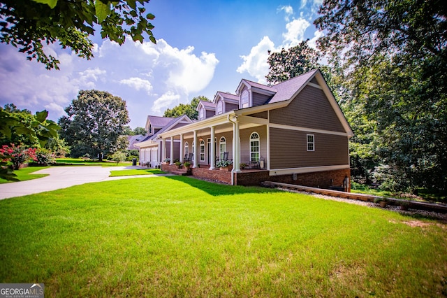 view of side of property with a porch and a yard