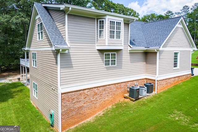 view of property exterior featuring central AC and a lawn