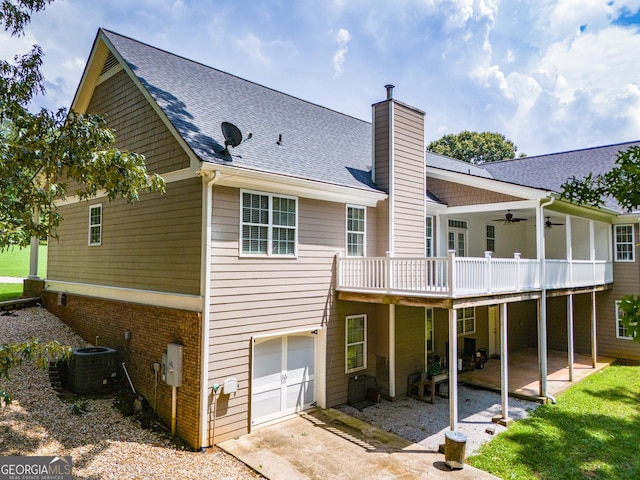 rear view of property with ceiling fan, a deck, a patio area, central air condition unit, and a garage