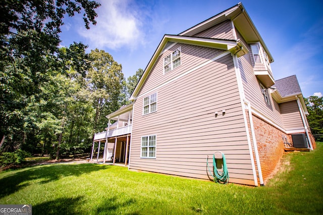 view of side of home with a lawn and a balcony