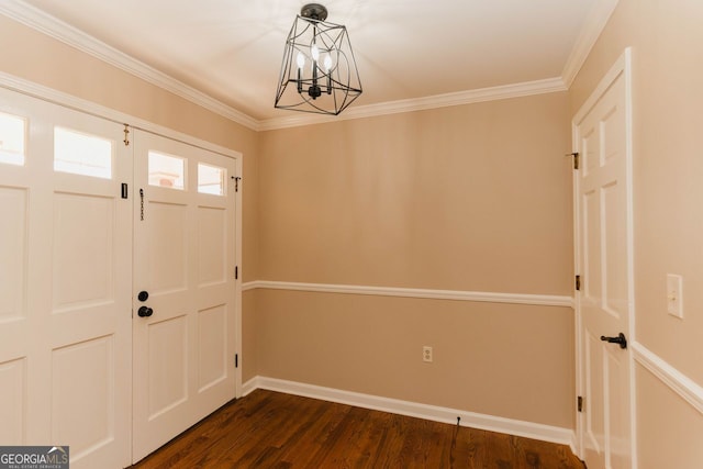 entrance foyer with an inviting chandelier, ornamental molding, and dark wood-type flooring