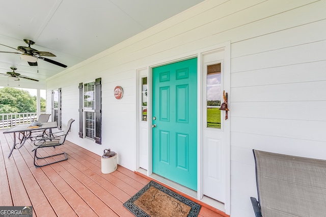 view of exterior entry with a porch and ceiling fan