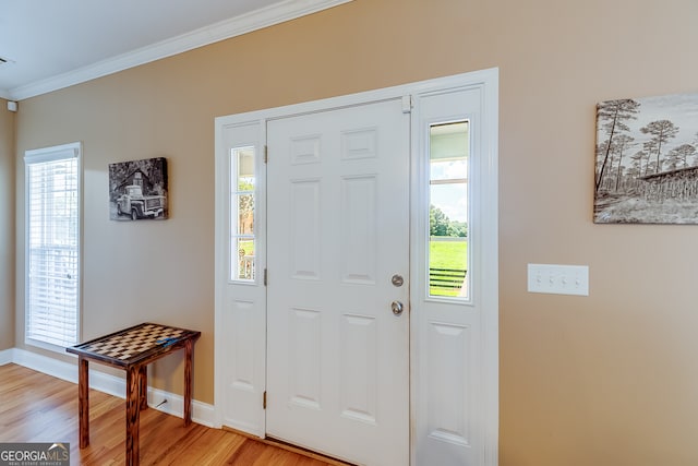 entrance foyer with light hardwood / wood-style floors and crown molding