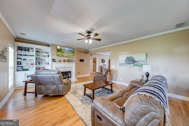 living room featuring light hardwood / wood-style floors, ornamental molding, and ceiling fan