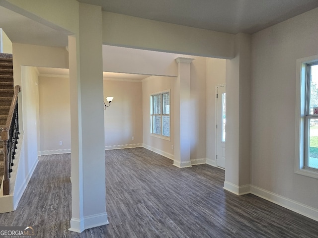 empty room with dark wood-style floors, stairs, and baseboards