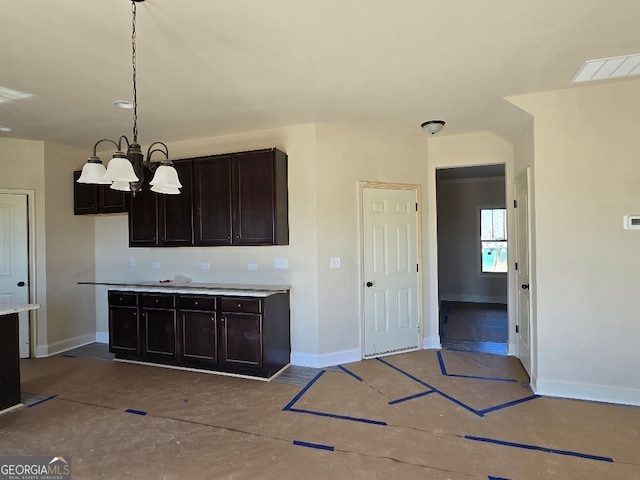 kitchen with dark brown cabinetry, decorative light fixtures, and a chandelier