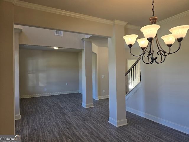 below grade area featuring a chandelier, dark wood-style flooring, visible vents, baseboards, and crown molding