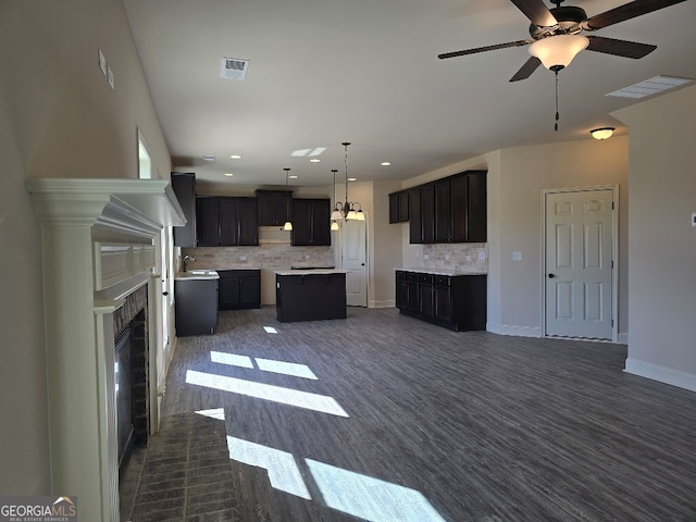 kitchen featuring visible vents, open floor plan, backsplash, and a center island