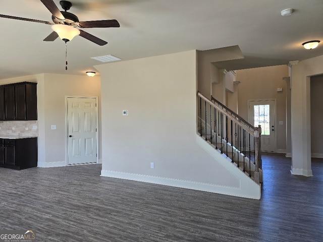 unfurnished living room with baseboards, visible vents, dark wood-style floors, ceiling fan, and stairs