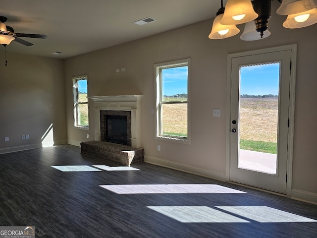 unfurnished living room featuring wood finished floors, plenty of natural light, a high end fireplace, and visible vents