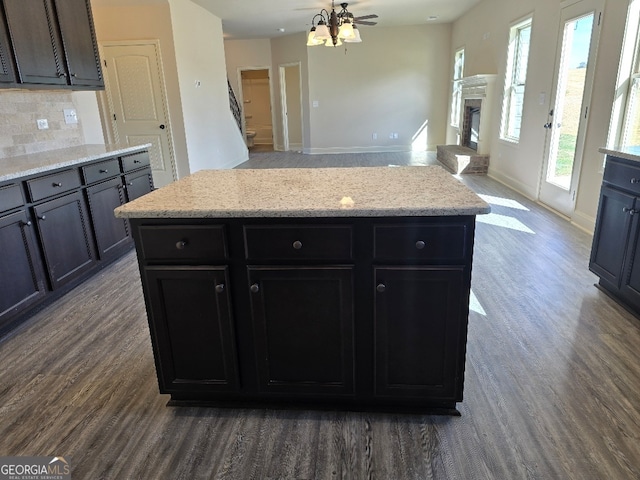 kitchen featuring dark wood-style floors, a fireplace, open floor plan, and decorative backsplash