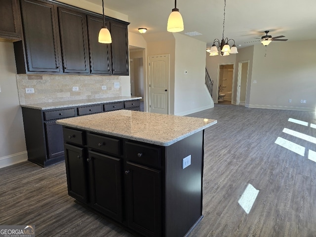 kitchen with dark wood-style floors, open floor plan, backsplash, and baseboards