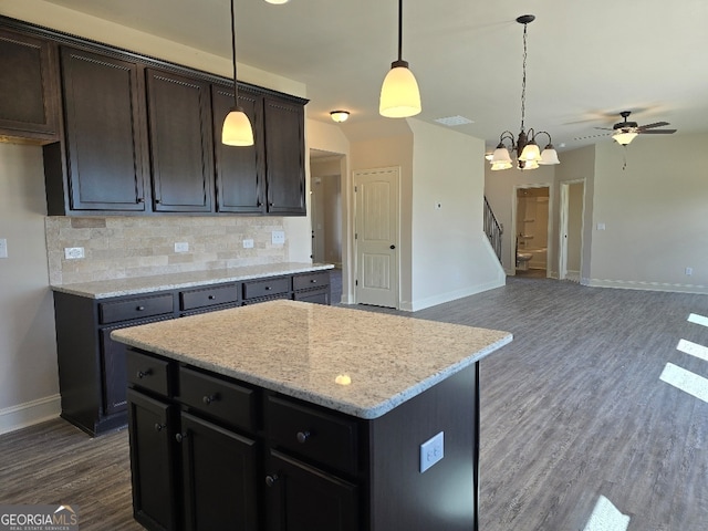 kitchen featuring dark wood-style floors, decorative light fixtures, decorative backsplash, open floor plan, and a kitchen island