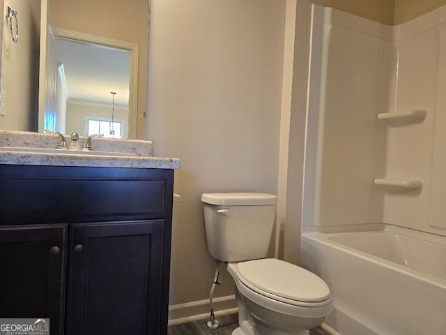 bathroom featuring toilet, washtub / shower combination, baseboards, and vanity