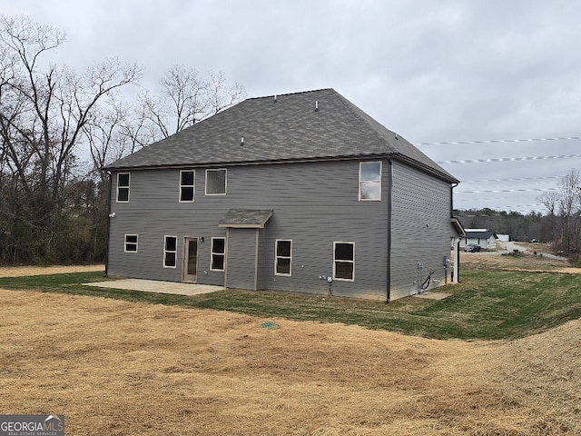 back of property with a yard and a patio