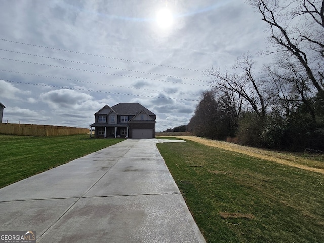 view of front of property with driveway, fence, and a front lawn