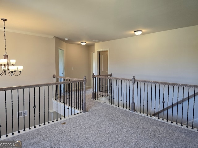 hall featuring an inviting chandelier, visible vents, carpet flooring, and an upstairs landing