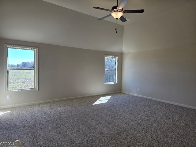 empty room with high vaulted ceiling, carpet flooring, a ceiling fan, and baseboards