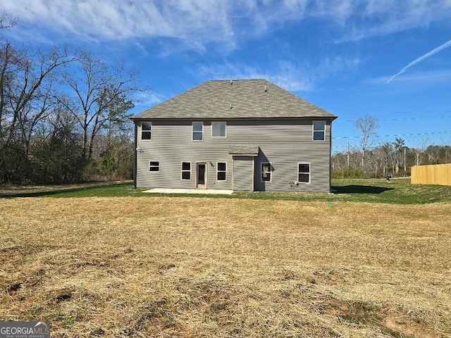 back of house featuring a patio area and a lawn