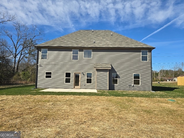 rear view of property featuring a lawn and a patio area