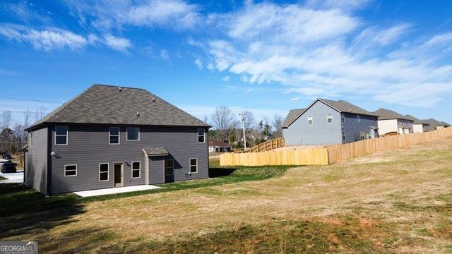 rear view of property with a lawn, fence, and a patio