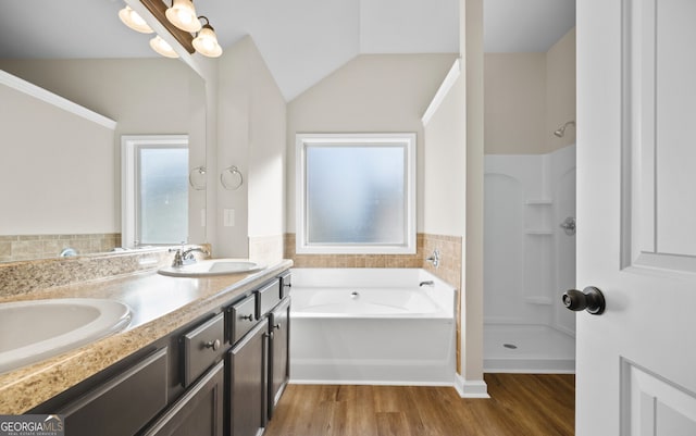 bathroom with shower with separate bathtub, lofted ceiling, vanity, and hardwood / wood-style floors