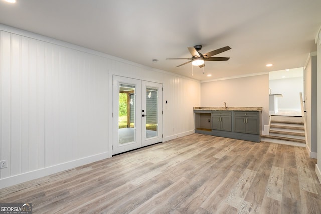 unfurnished living room featuring crown molding, hardwood / wood-style flooring, sink, and ceiling fan