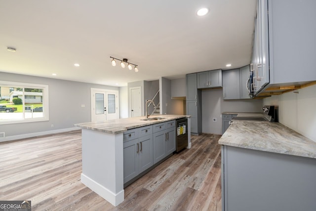 kitchen featuring light hardwood / wood-style flooring, stainless steel electric range oven, an island with sink, sink, and gray cabinets