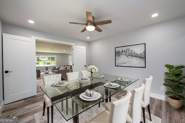 dining space with hardwood / wood-style floors and ceiling fan